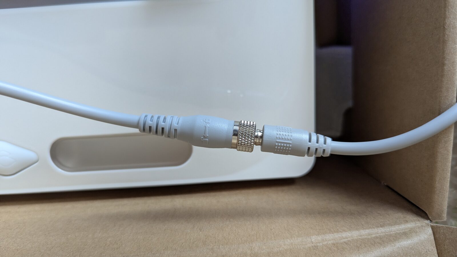 Gros plan du connecteur à vis entre l'adaptateur secteur et le robot laveur de vitres