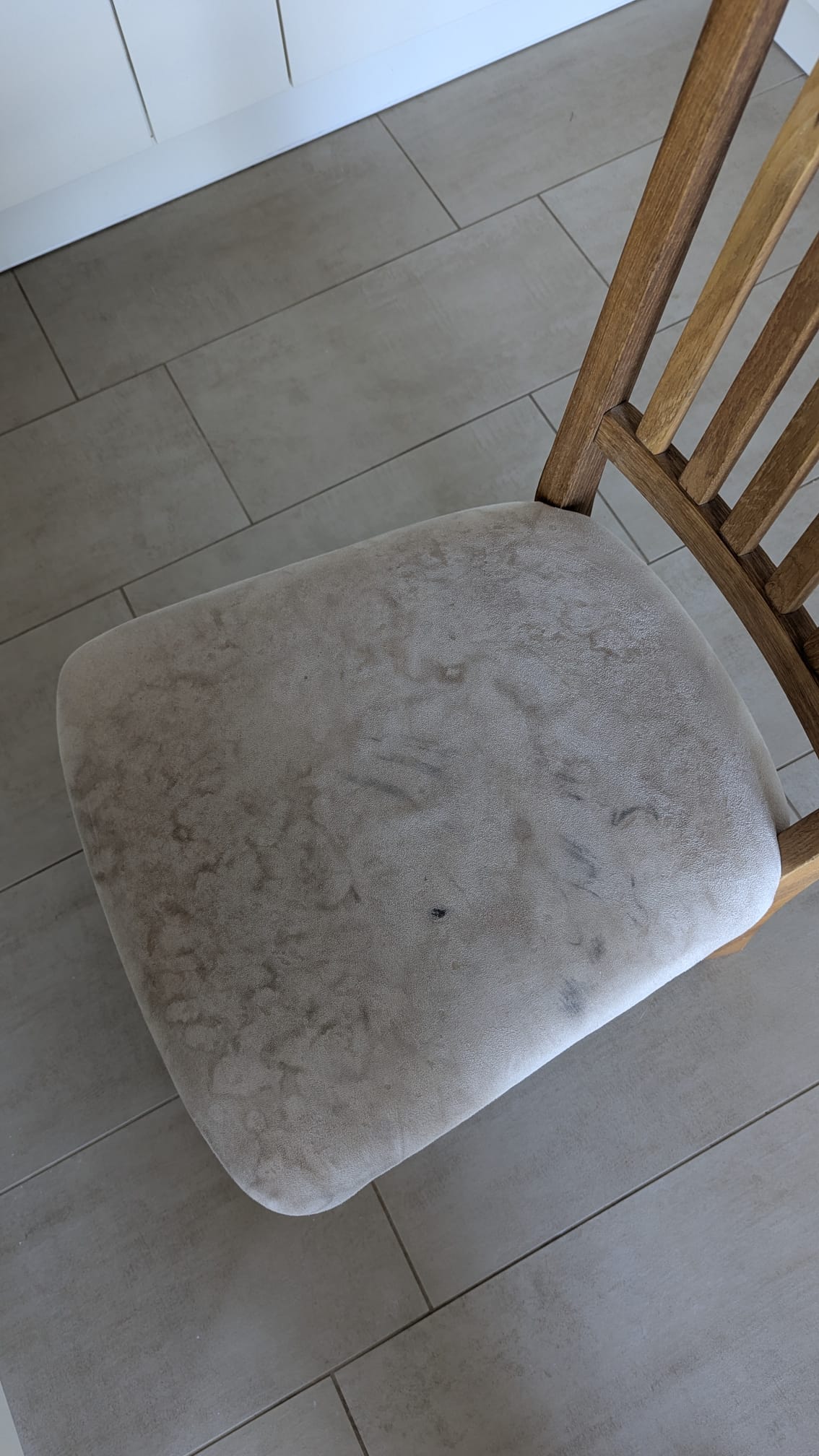 Assise de chaise avant nettoyage avec des taches sombres et une saleté clairement visibles